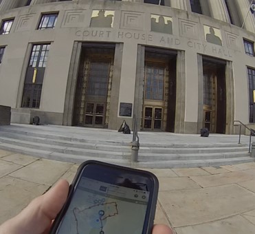 Photograph of participant approaching the downtown Nashville  court house holding smartphone