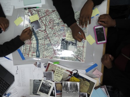 Photograph of high school students adding archival material to a historic base map